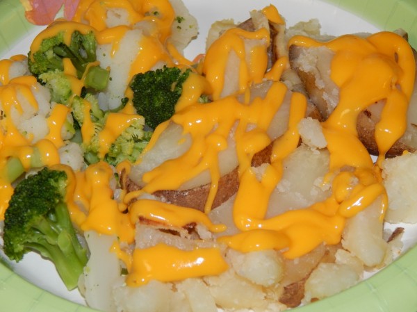 nacho cheese sauce over veggies and potatoes